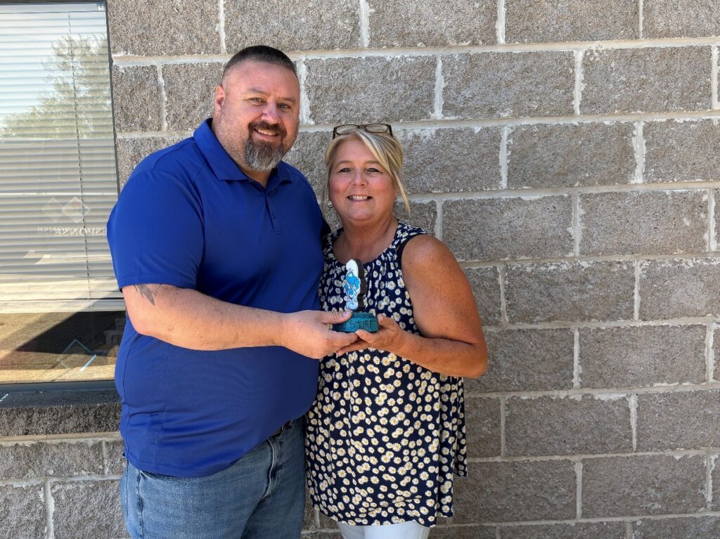 Man and woman holding blue Smurf in honor of Men's Health Awareness